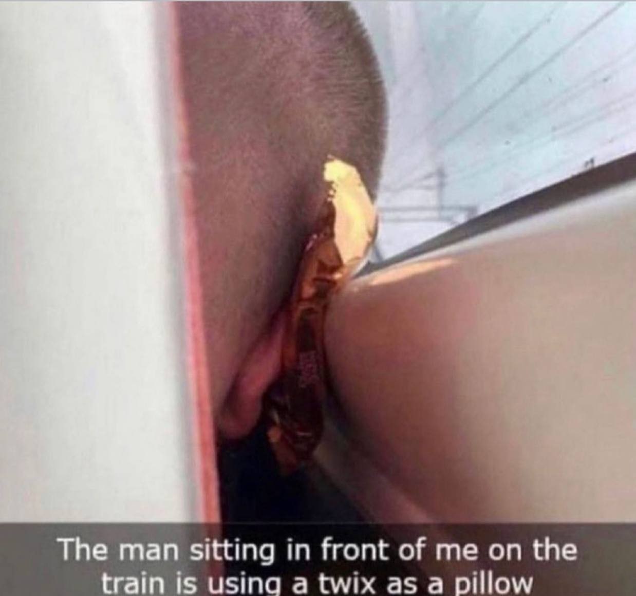 The man sitting in front of me on the train is a twix as a pillow