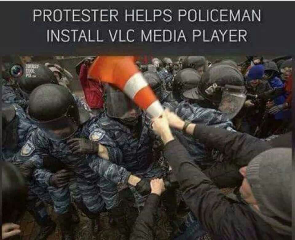 PROTESTER HELPS POLICEMAN INSTALL МЕС MEDIA PLAYER