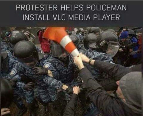 PROTESTER HELPS POLICEMAN INSTALL МЕС MEDIA PLAYER