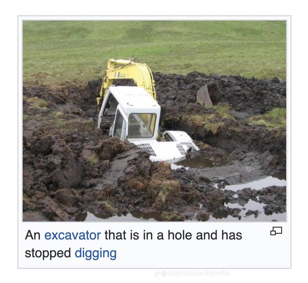 An excavator is a hole and has stopped digging