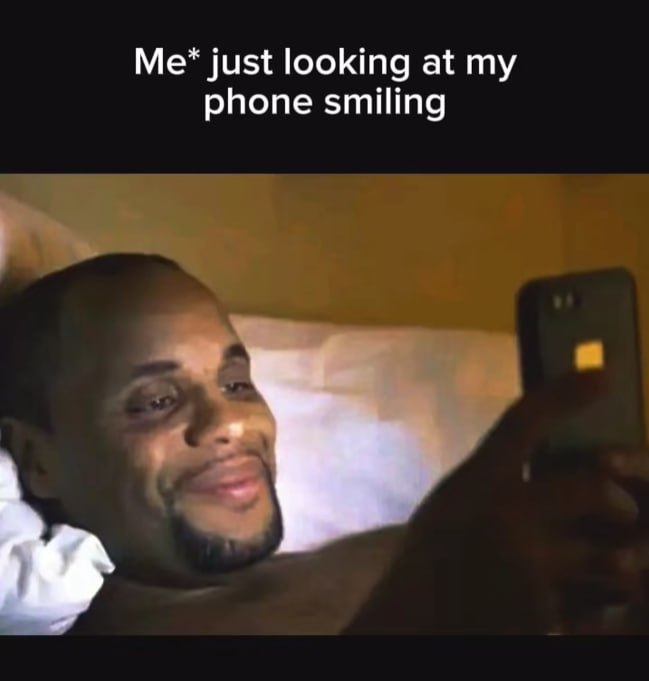 just looking at phone smiling